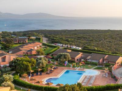 Resort mit Pool, Meerblick und Villen in grüner Umgebung.