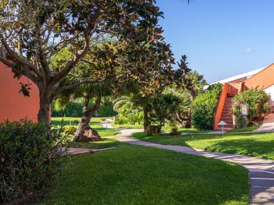 Garten mit Weg, Bäumen und orangefarbenem Gebäude.