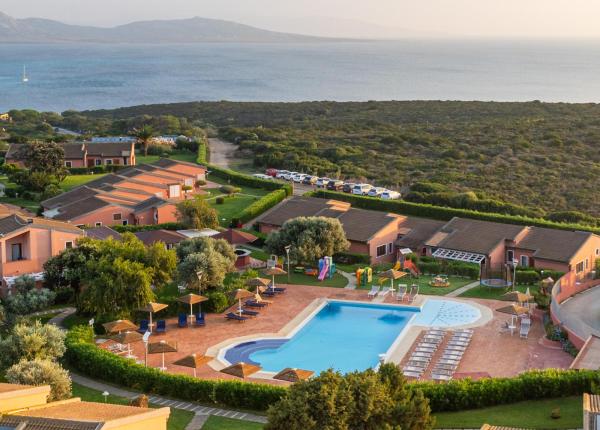 Resort mit Pool, Meerblick und Villen in grüner Umgebung.