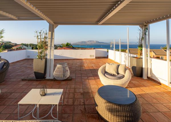 Terrasse mit Meerblick, moderne Möbel und Pflanzen.